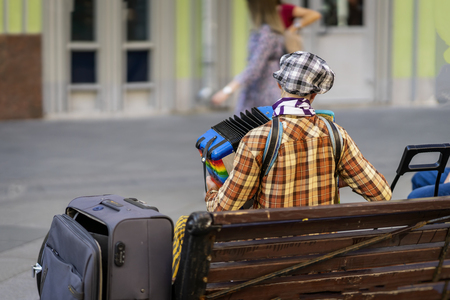 Street musician, bright retro hipster, with an accordion, real performance in the city, outdoors, outsideの写真素材