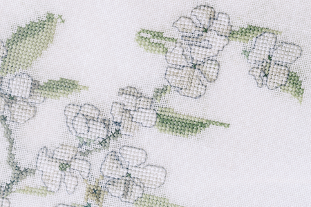 Fragment of a colorful cross-stitch embroidery, flower summer ornament