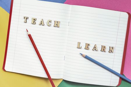Teach and learn, words in open notebook, colored paper sheets. Concept of education, starting school, back to school. Colorful backgroundの写真素材