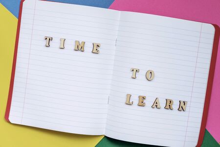 Time to learn, text in an open notebook, colored paper sheets. Concept of education, starting school, back to schoolの写真素材