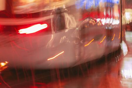 Old wagon of tram, golden abstract blurred city background at night, rainy late evening, sparkling...