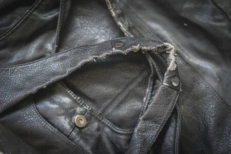 Old, crumpled and dirty leatherette bag, bag handles with metal rivets closeup, texture. Worn material with stains and crumbling surfaceの写真素材