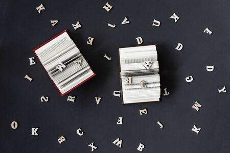 Pair of open books and letters of the English alphabet on a dark background. Education, study, reading, back to school conceptの写真素材