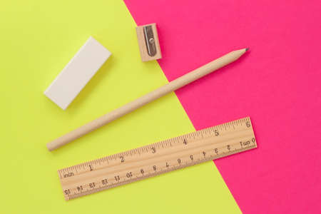 Set of stationery on a bright yellow-pink background, top viewの写真素材