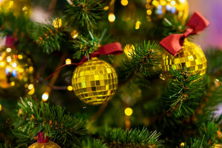 Christmas tree with decorations, shiny golden balls, illumination light garlands. Abstract festive...