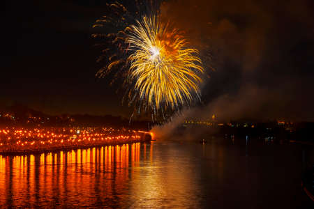 Festive vivid golden fireworks, bright reflection in the lake. Celebration. Abstract blurred holiday background.の写真素材