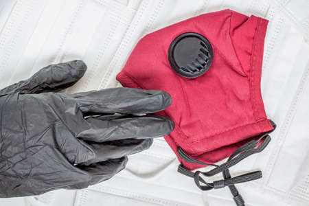 Hand in black glove and protective medical masks, respirator. Personal protective equipment. Concept...
