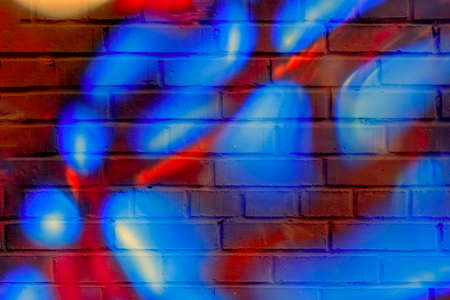 Brick wall decorated with bright rounded spots. Detail of a graffiti. Modern stylish background.の写真素材