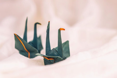Colorful Origami Cranes close-up on pink background. Romantic handmade decorの写真素材