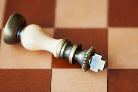 Chess board with the fallen king close-up