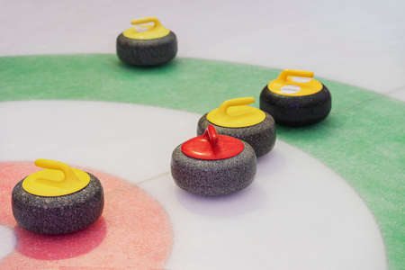 Curling stones on playing field on ice rinkの写真素材