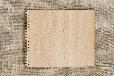 Open sketchbook with craft paper on spiral, vintage background of sack, copy spaceの写真素材