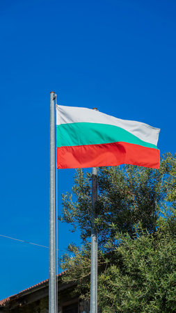 National flag of Bulgaria waving in the wind on the flagpole in blue skyの写真素材