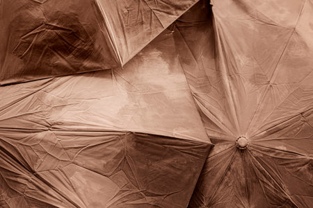 Closeup of overlapping wrinkled umbrellas in monochrome brown sepia colorの写真素材