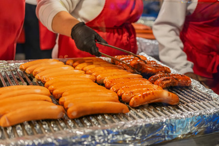 Grilled sausages cooking on barbecue grill close-up. Street food concept with freshly roasted meatの写真素材