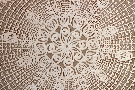 Cream craft lace doily, vintage textured background. Vintage lace doily with intricate cutout patterns on a neutral background. Delicate and classic decorative textile for elegant designsの写真素材