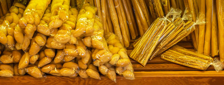Packed breadsticks and bread rolls arranged on wooden shelves inside local bakery. Colorful...