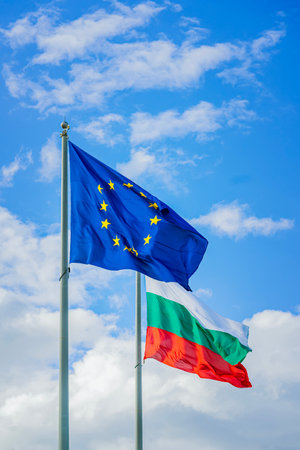 European Union and Bulgarian flags waving together on tall poles against blue sky. Concept of international unity, partnership, international relations, national identityの写真素材