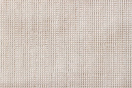 Closeup of beige fabric texture with subtle grid pattern and soft fiber structure. Concept of...