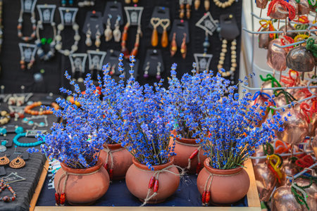Lavender Festival, Bulgaria. Bunches of dried lavender in clay pots surrounded by handmade jewelry at craft market. Concept of lavender decor, folk tradition, artisan design, rustic handmade lifestyleの写真素材