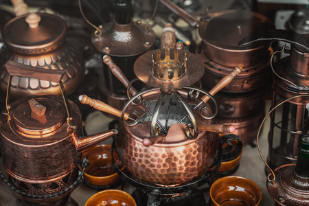Copper fondue set and Vintage Utensils. Utensils arranged in rich detail with warm reflections and...