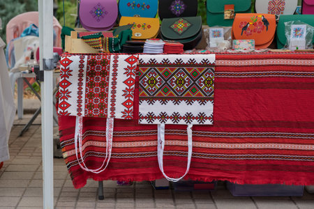Colorful handmade Bulgarian textile with geometric embroidery and ethnic bags presented at folk...