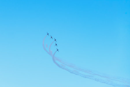 Airplanes on airshow. Five military jets performing an air show formation with smoke trails against...