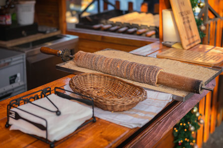 Trdelnik, also known as chimney cake, is freshly baked and covered in sugar at festive Christmas market stand. Concept of Trdelnik, sweet tradition, authentic holiday street foodの写真素材