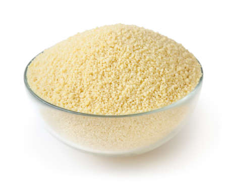 Uncooked couscous in glass bowl isolated on white background with clipping pathの写真素材