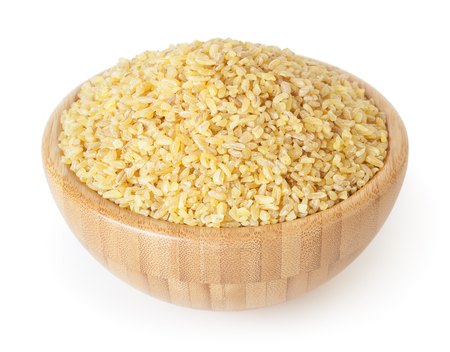 Uncooked bulgur in wooden bowl isolated on white backgroundの写真素材
