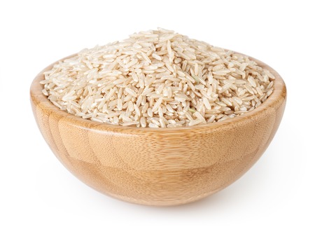 Brown rice in wooden bowl isolated on white backgroundの写真素材