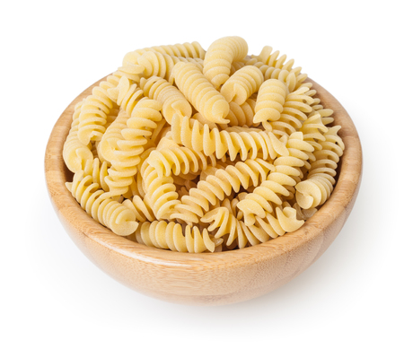 Uncooked fusilli pasta in wooden bowl isolated on white backgroundの写真素材