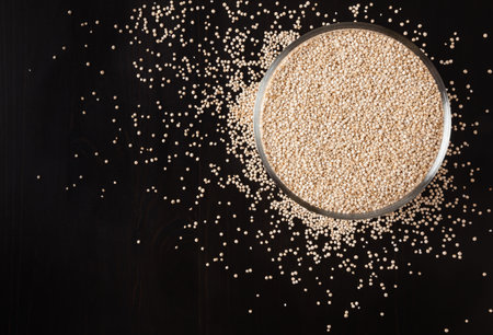 Dried white quinoa seeds on black wooden backgroundの写真素材