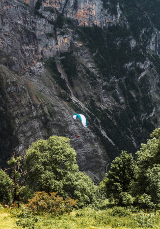 Lauterbrunnen, Switzerland, Jungfrau in Swiss Alps. Cozy village in mountains. Extreme sport, paraglider and parachute.の写真素材