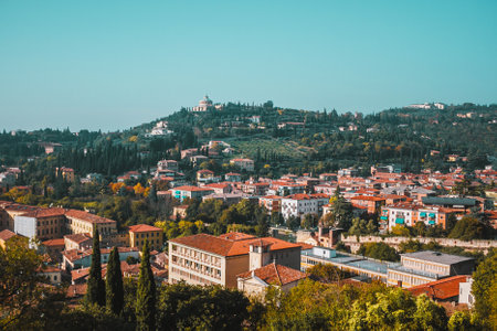 Sunny day in Verona centre, Italy. Panoramic view from above on streets, landmarks and green hillsの写真素材
