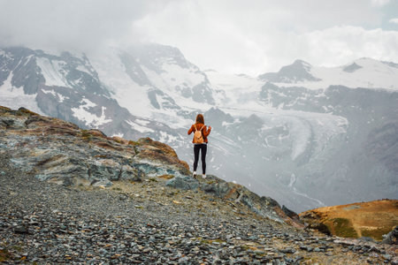 Woman with backpack on mountain background. Top of Gornergrat, Zermatt, Swiss. Hiking in Alpsの写真素材