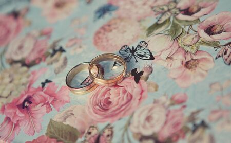Two wedding rings of white gold on a blue butterflies background. Wedding ringsの写真素材