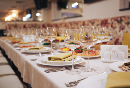 Glassware and cutlery for catered event. Beautiful table setting with crockery for a party, wedding reception or other festive event.の写真素材