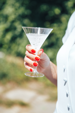 female hands holding a glass of champagne. close-up.の写真素材