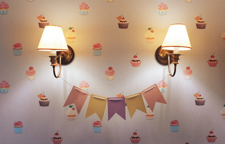 Wall lamp in the children's room. Chandelier in the children's room. Close-up. Flags between the lamp. Cake Wallpapers.の写真素材