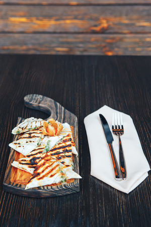 Grilled pita bread with cheese on a wooden board.の写真素材