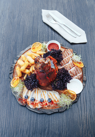 Roasted pork or lamb leg with sauce. Fried pork leg with sauce on a cutting wooden board. wooden background.の写真素材