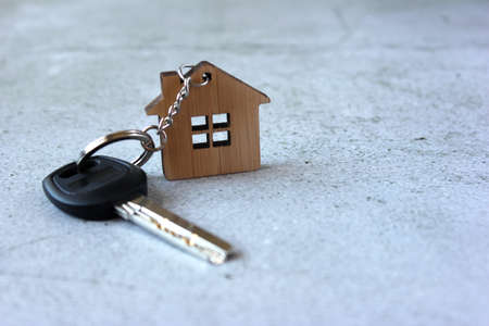 House key and keychain on a concrete background with copy space. Home purchase concept, mortgage.