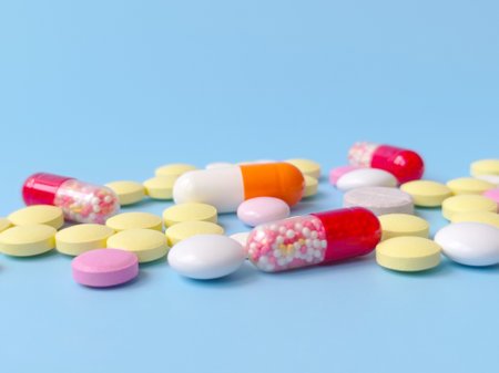 Multicolored pills on a blue background. The concept of medicine, pharmacy. Banner with copy space. Stock photography with selective focus.の写真素材