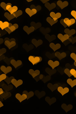 Gold hearts bokeh on black background
