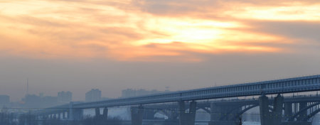 city at dusk, city buildings against the sky, polluted air, poor ecology, railway bridgeの写真素材