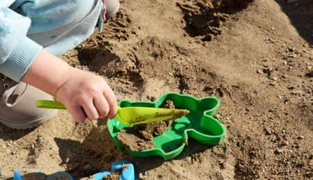 a child sculpts sand animals, sand molds, childrens toys, sandbox games, beach holidays, entertainment for childrenの写真素材