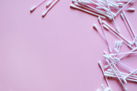 cotton swabs on a pink background on the right, cosmetic and medical accessories, a beauty salon banner, with a place for textの写真素材