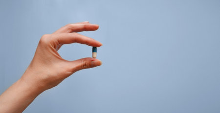 capsule in hand on a blue background, medication, medical workers day, medical care, banner for the hospitalの写真素材