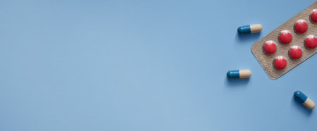 background for a medical website or article, packs of pills and capsules on a blue background,...